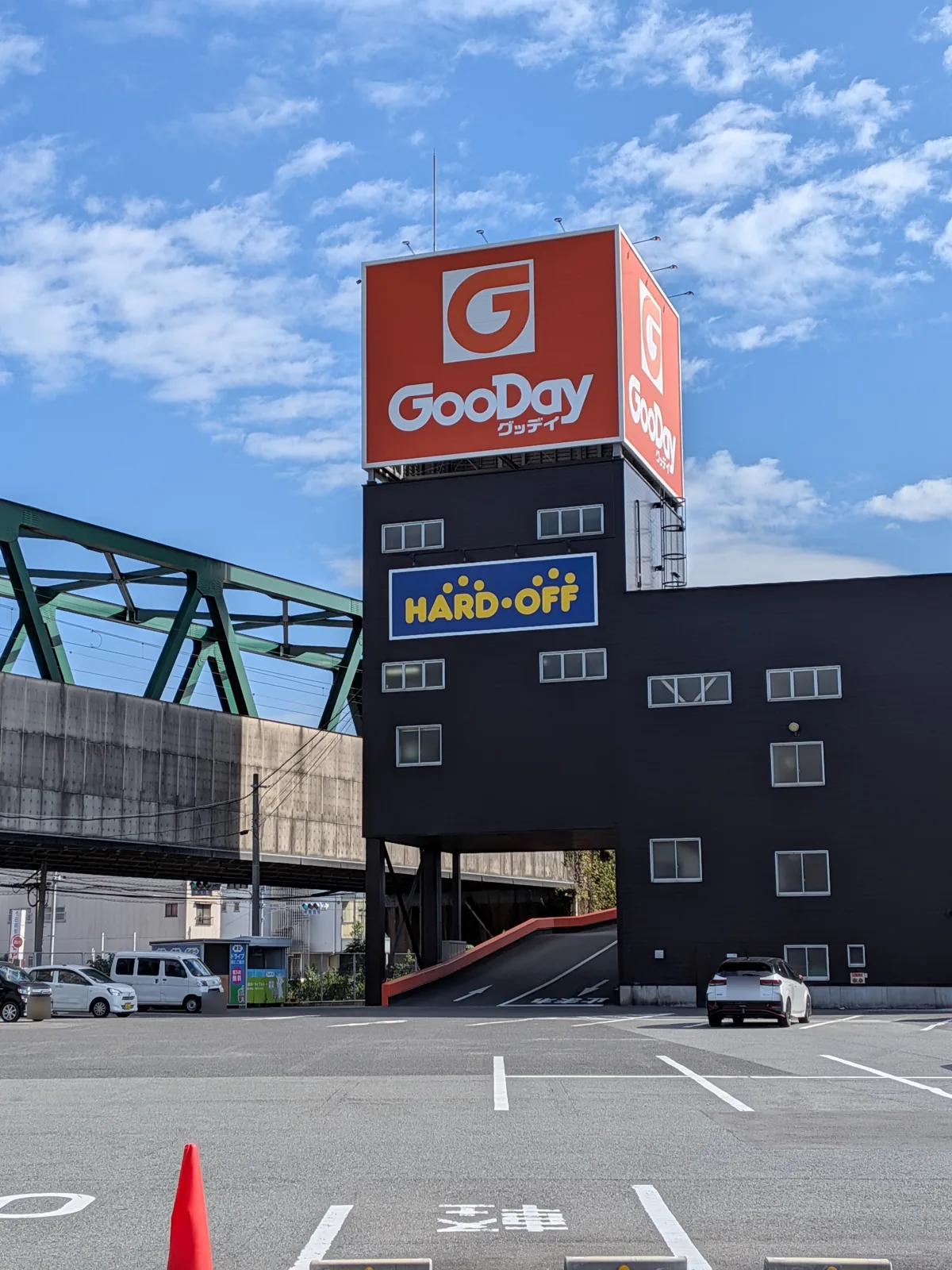 駐車場から見たグッデイの看板塔とハードオフの看板