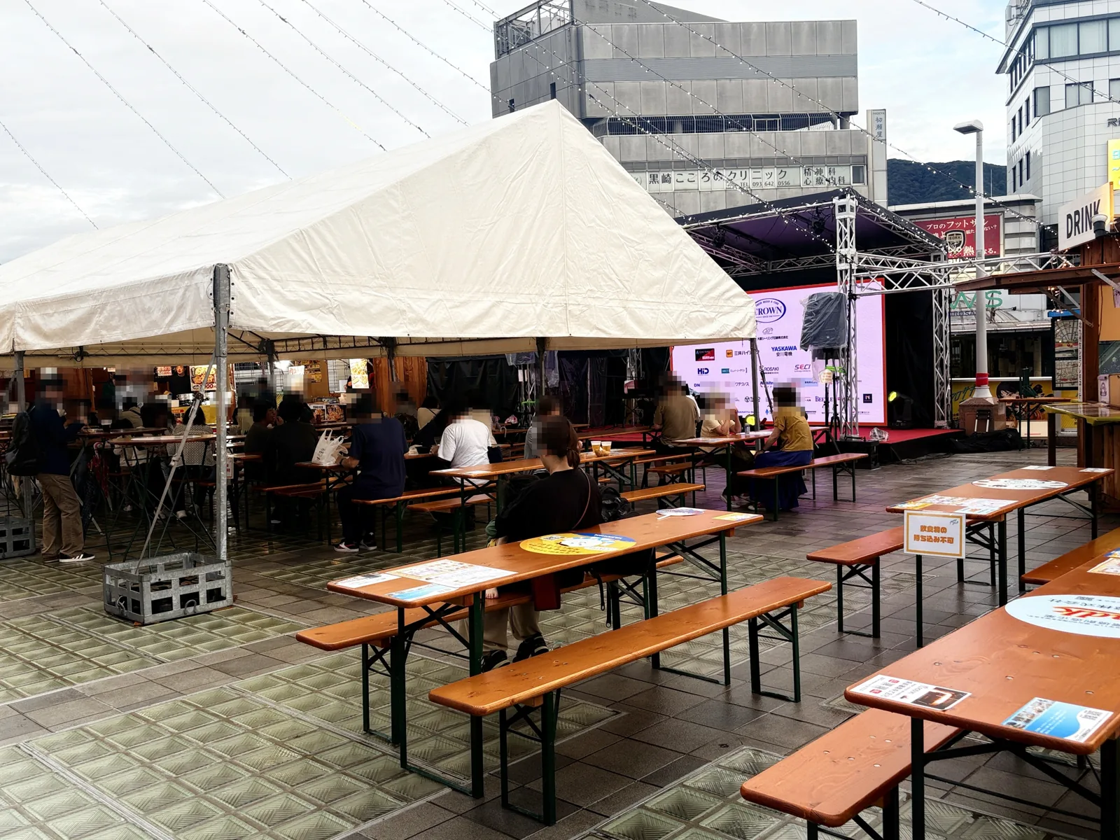 雨あがりのステージ前。テントの横の屋外テーブル席に空きがある