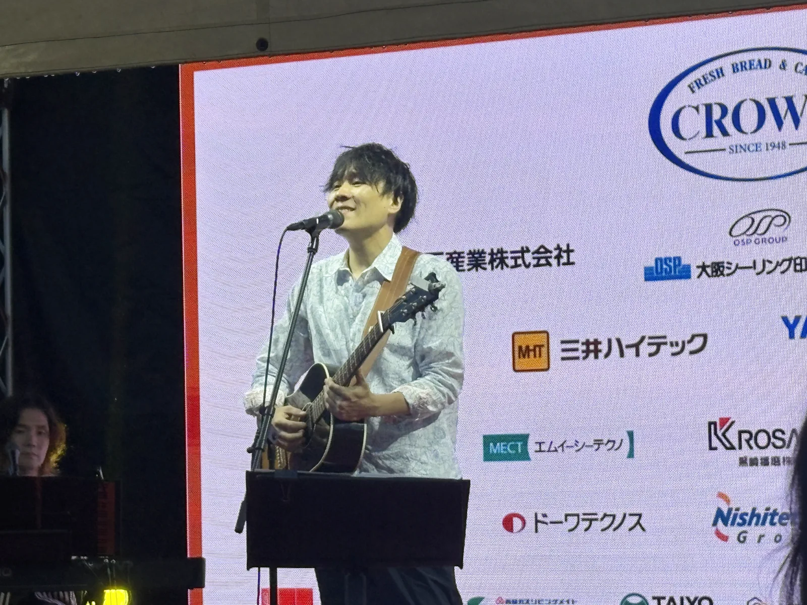 ステージでギターを弾きながら歌う立川翼さん