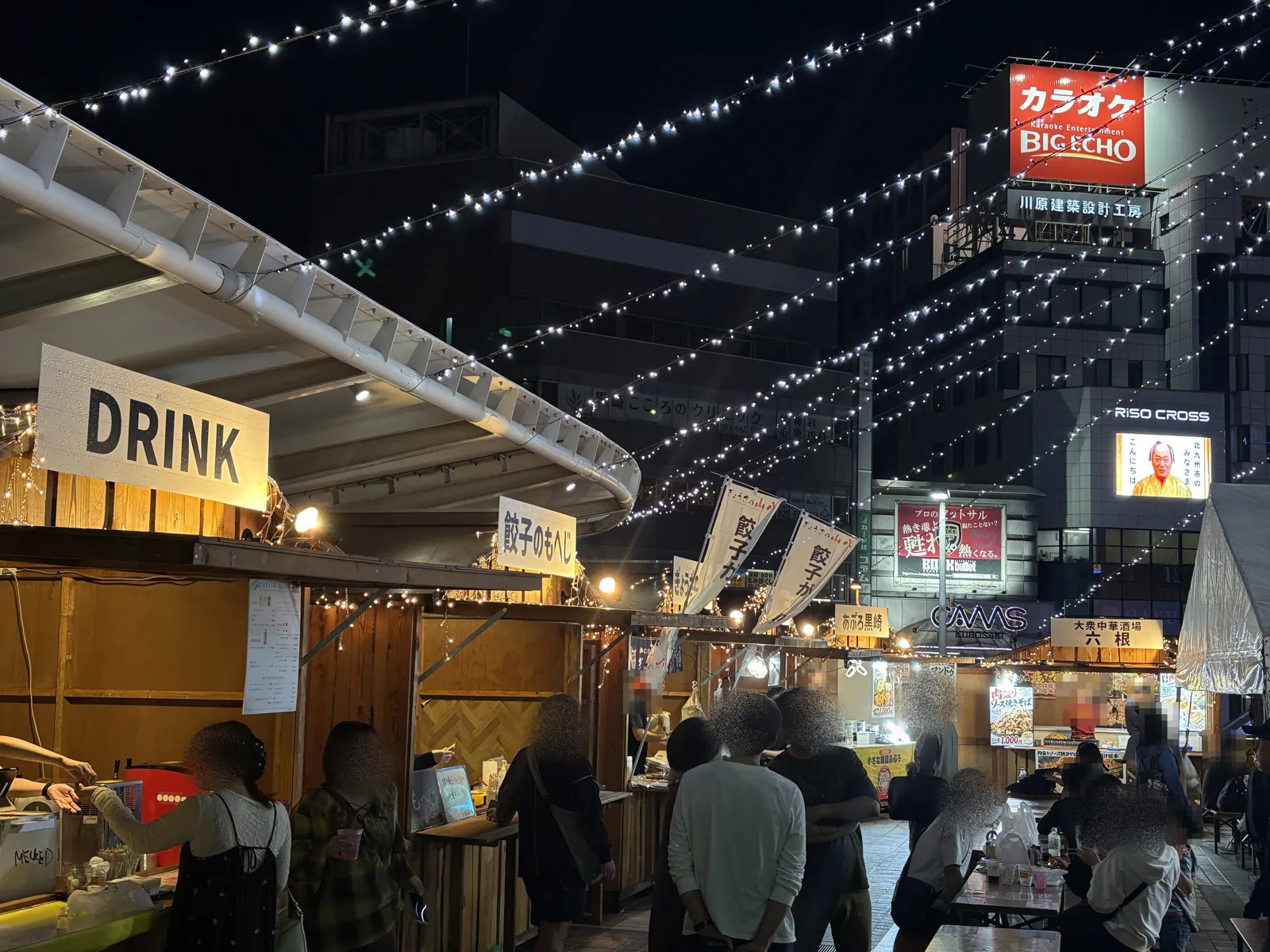夜の会場。餃子のもへじやあぷろ黒崎、六根の屋台の前に人が集まる