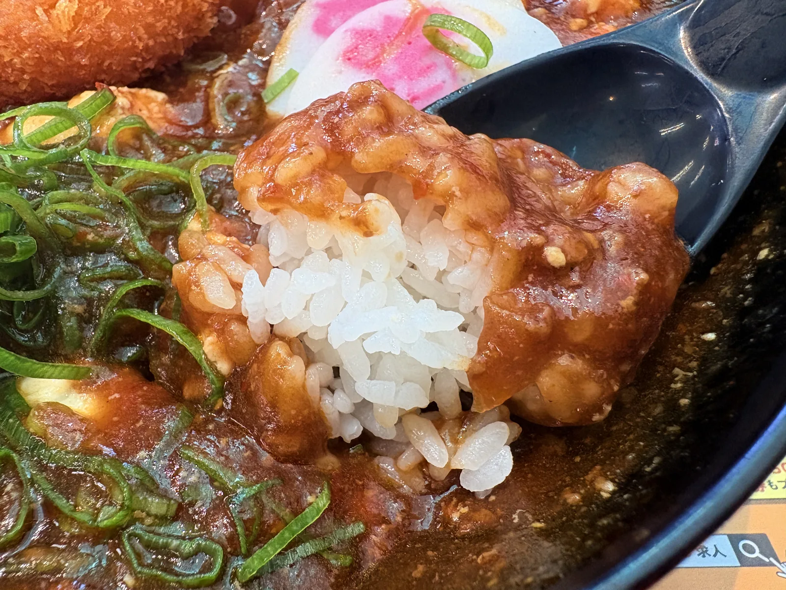 レンゲにすくったごはんに、豆腐と麻婆のあんが絡んでいる