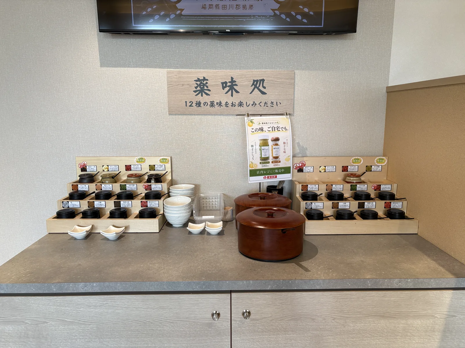 「12種の薬味をお楽しみください」と書かれた薬味処。小さな壺の薬味が並ぶ